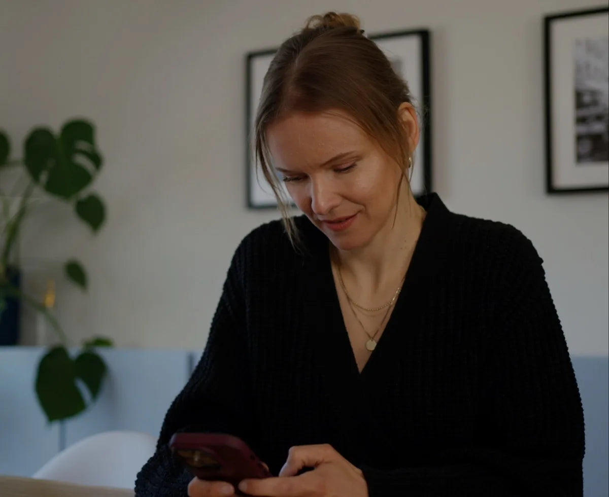 Frau tippt zu Hause auf ihrem Handy
